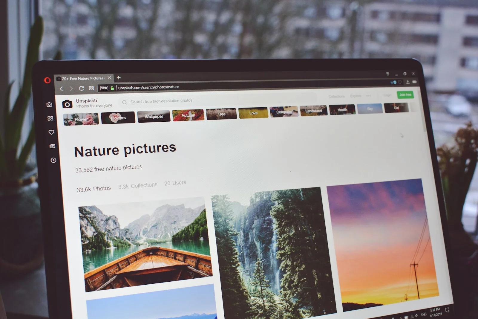 Laptop screen showing Unsplash search results for free nature pictures, ready to choose for web use