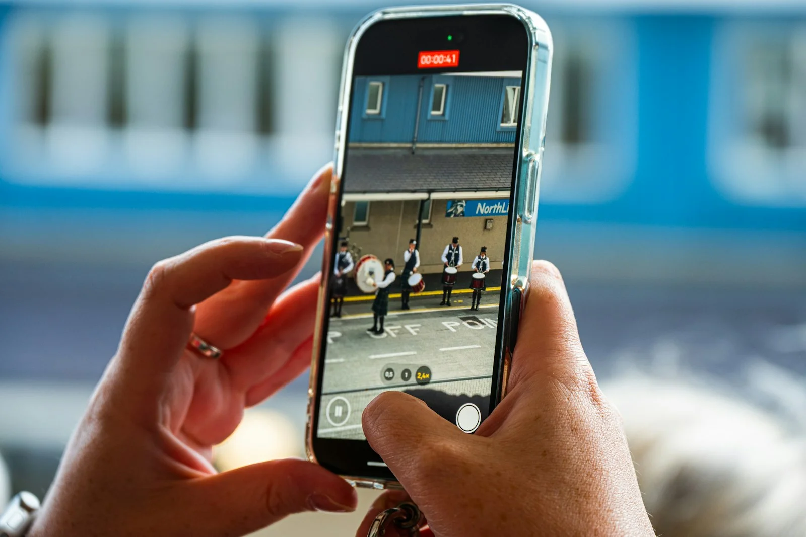 Hands holding a smartphone recording a subway platform - Photo by Julia Taubitz on Unsplash Hands filming kilted pipe band drummers on a smartphone, capturing a local community event on mobile